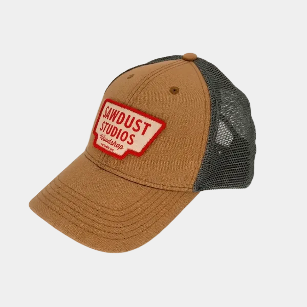 Brown cap with black mesh back and red 'Sawdust Studios' logo on a white background