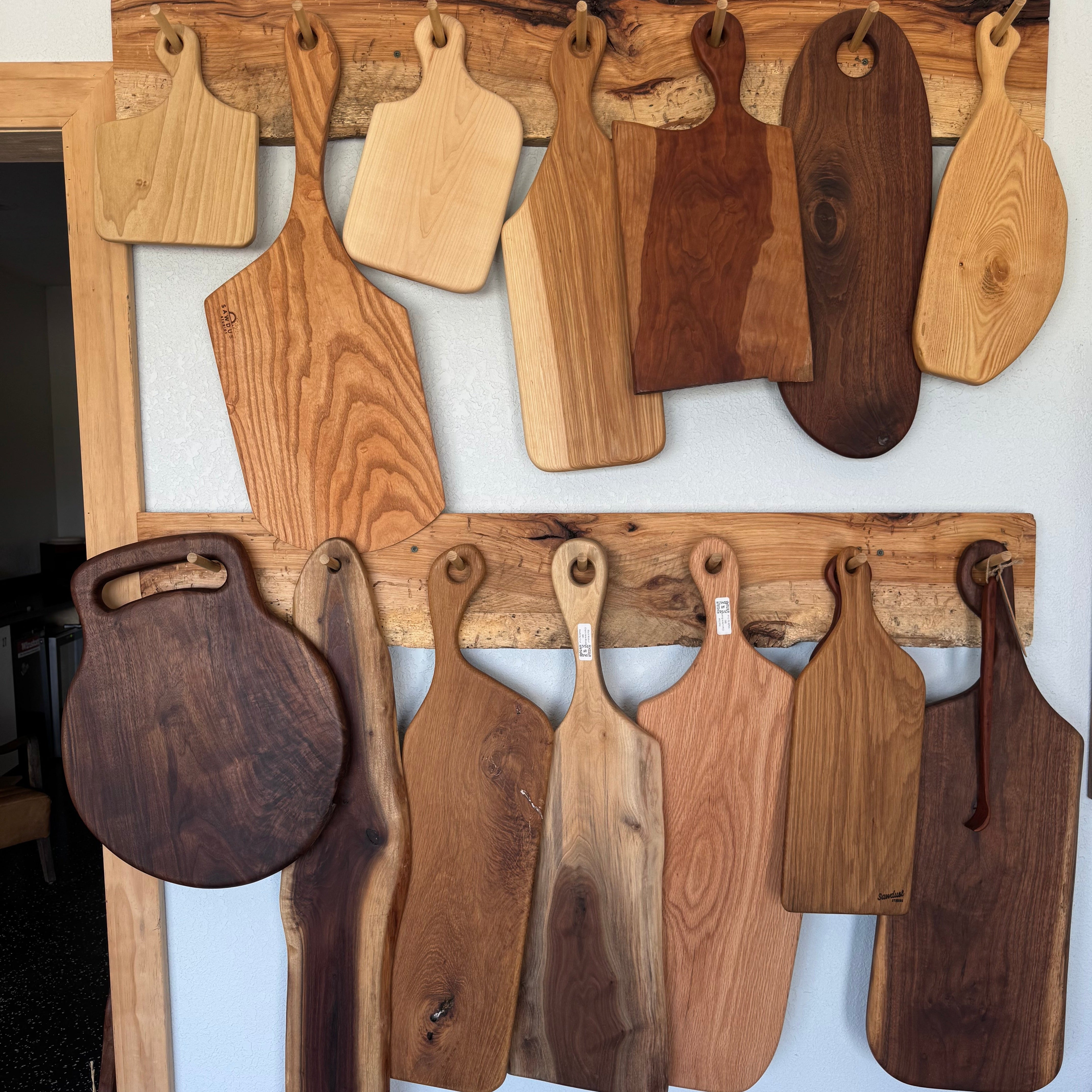 Collection of wooden cutting boards displayed on a wall.